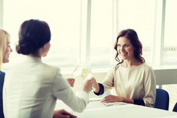 Fototapeta premium happy women drinking champagne at restaurant