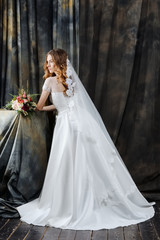 Fototapeta na wymiar portrait of pretty bride in wedding dress with flowers