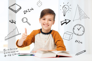 happy student boy with textbook showing thumbs up