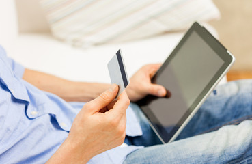 close up of man with tablet pc and credit card