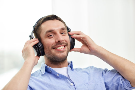 smiling young man in headphones at home