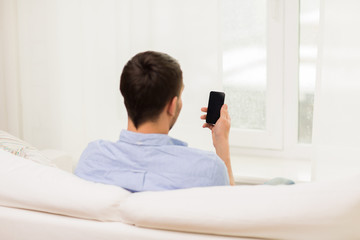close up of man with smartphone at home