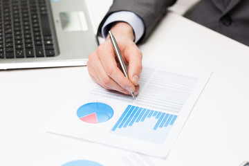 close up of businessman hand with charts in office