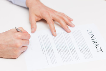 close up of male hands signing contract document