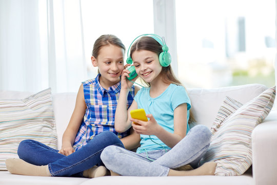 happy girls with smartphone and headphones