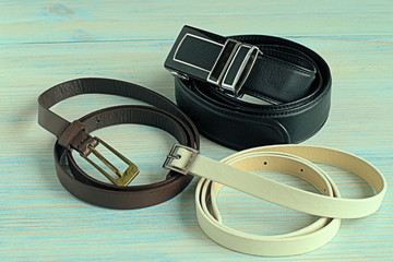 Accessories.  Three leather strap on a blue wooden background.