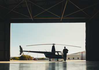  Pilot arriving at the airport with a helicopter in hangar © Jacob Lund