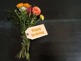 Happy Birthday - ein Blumenstrauß mit Textnachricht auf dunklen