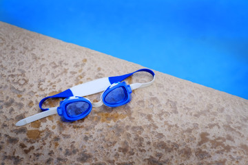 Blue Swim Goggles Next to Swimming Pool
