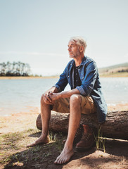 Mature man relaxing by a lake