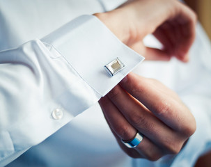 Groom buttons on his shirt cuffs