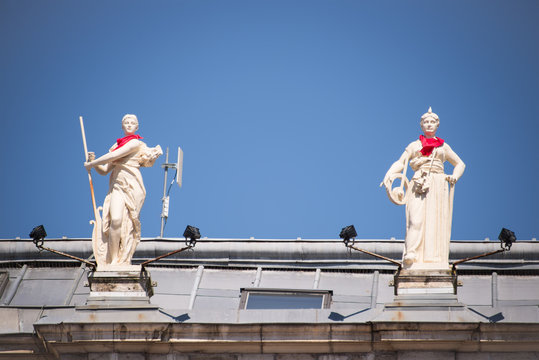 Statues on the roof of the city hall of Bayonne with a red scarf during the Summer festival (Fetes de Bayonne), France
