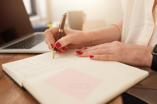 Businesswoman writing in her personal organizer