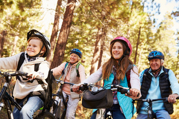 Grandparents and grandkids cycling on forest trail, close up