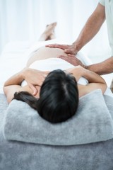 Obraz na płótnie Canvas Pregnant woman receiving a stomach massage from masseur