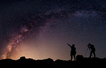 Fototapeta na wymiar Star-catcher. A person is standing next to the Milky Way galaxy