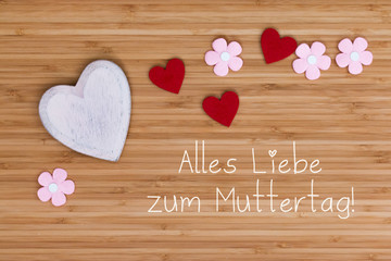 Hintergrundgrafik mit Text "Alles Liebe zum Muttertag", Holzherz, rote Herzen und Blümchen auf Holzhintergrund