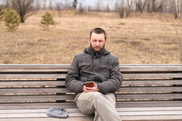 Obraz premium Sad man with smartphone on a bench