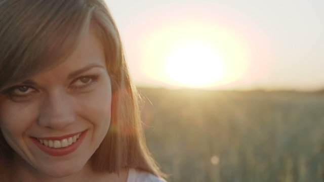Woman opens her eyes and feels happy at sunset
