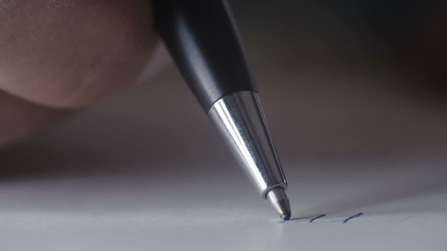 Woman with a pen writes the word