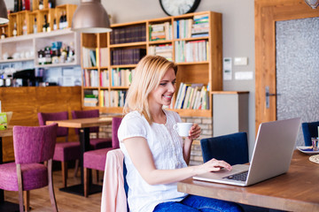 Blond woman with notebook in cafe drinking coffee