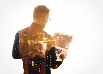 Double exposure  young bearded businessman wearing black shirt and holding contemporary notebook...
