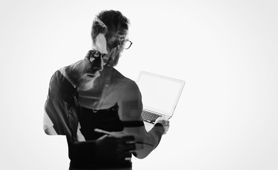 Double exposure young bearded businessman wearing black shirt and holding contemporary notebook...
