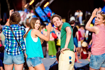 Teenagers at summer music festival clapping and singing