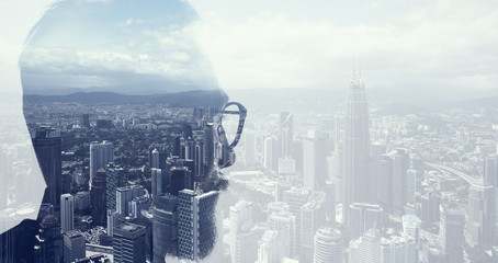 Closeup photo of bearded banker wearing glasses and looking city. Double exposure, panoramic view contemporary megalopolis background. Space for your business message. Wide