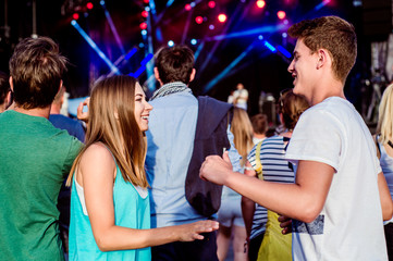 Naklejka premium Teenagers at summer music festival having fun, dancing