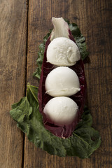 Mozzarelle di bufala Napoletane su un letto di verdure - sfondo tavolo di legno