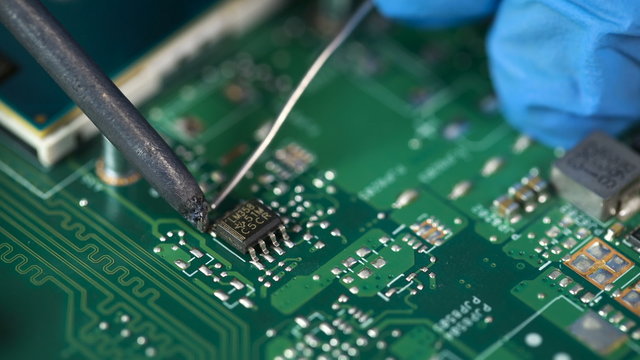 accuracy. Electronic lab working place with soldering iron and circuit board