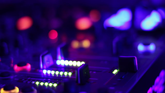 Glowing buttons on professional audio equipment in the night club. DJ, party