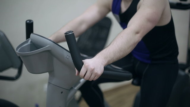 Men exercising in gym for weight loss and wellness man training on cycle or cardio bike in fitness club