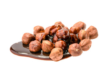 Hazelnuts and chocolate syrup isolated on white