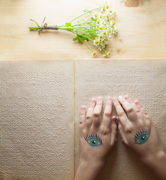 reading Braille at the table with a bouquet of flowers