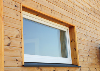 Close up on Plastic PVC Window in New Modern Passive Wooden House Facade Wall. PVC Windows are the Number One in Energy Efficiency.