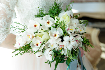 Beautiful white wedding bouquet in hands of the bride