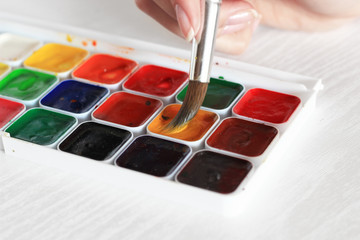 process of Painting with watercolors, a palette and brush in hand
