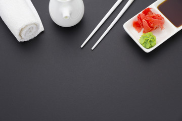 All for sushi. Ginger wasabi soy sauce and chopsticks over black background.