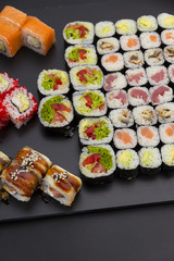 Sushi set on a black plate over dark background