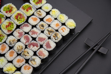 Sushi set on a black plate over dark background