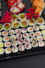 Sushi set on a black plate over dark background