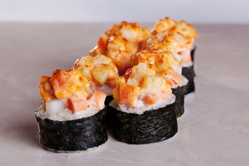 Roll cap salmon and perch, sesame, unagi on a white background isolated close-up menu for sushi oriental