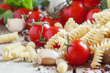 Dry pasta fusilli with tomatoes, selective focus