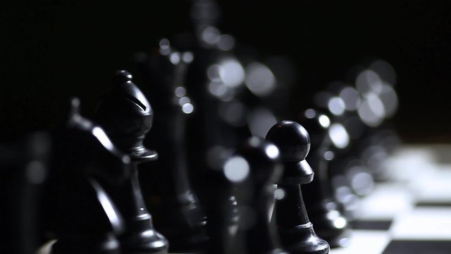 Arrangement of black chess pieces on chess board.
