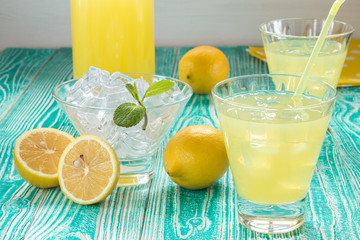 lemonade or limoncello in glasses with ice cubes, sherbet glass with ice cubes decorated by mint...