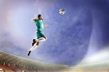 Fototapeta na wymiar Athlete heading soccer ball in stadium