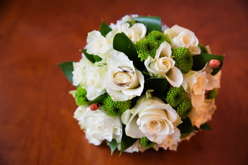 Beautiful bridal bouquet of flowers and wedding rings