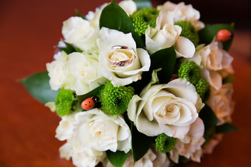 Beautiful bridal bouquet of flowers and wedding rings